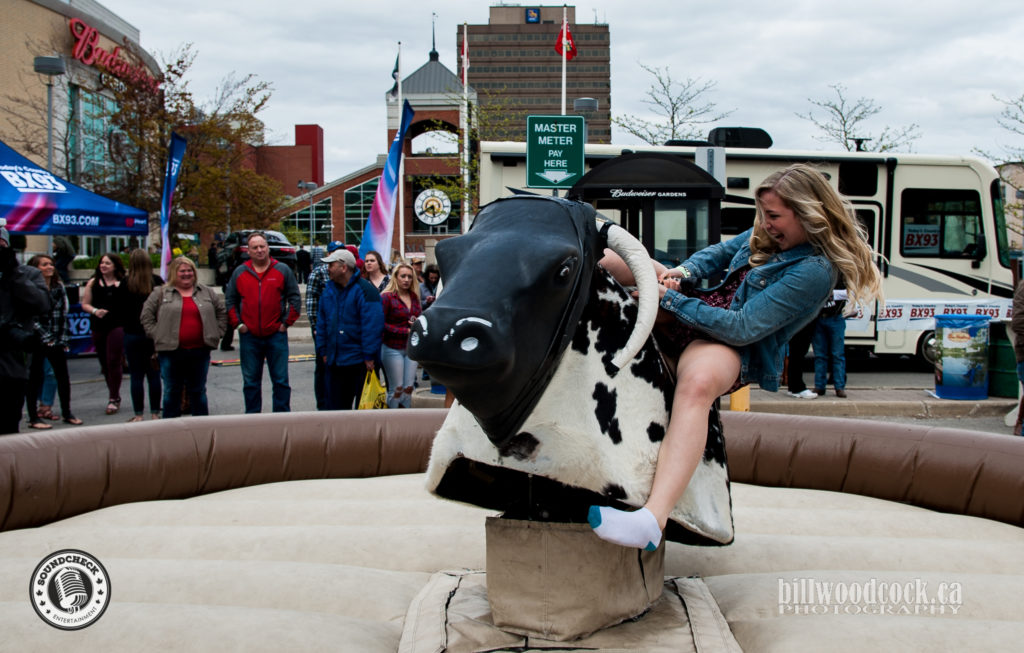 Riding the mechanical bull at the Bud Gardens Pre-Show Tailgate Party - Bill Woodcock 